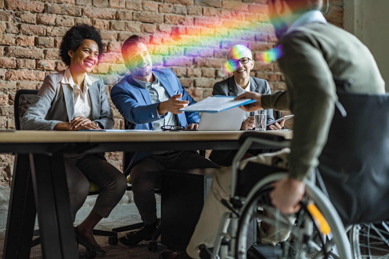 A diverse board meeting, including a director who uses a wheelchair